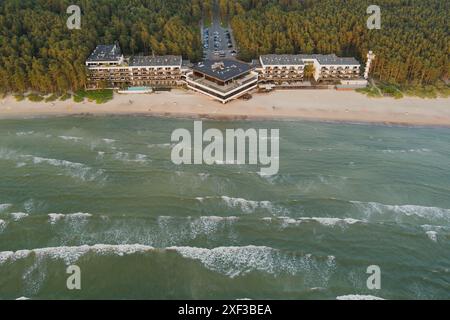 La plage centrale de Pirita un soir d'été au coucher du soleil, il y a des vagues et de l'eau boueuse dans la mer, photo vue d'un drone. Banque D'Images