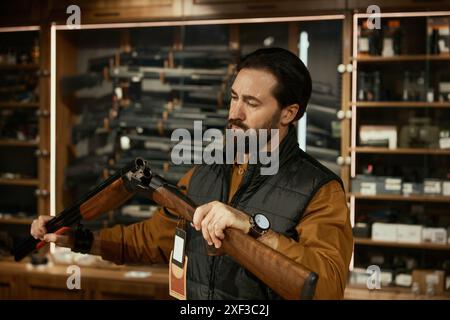 Vendeur concentré vérifiant l'arme à feu tout en travaillant dans un magasin d'armes Banque D'Images