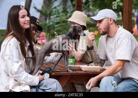 Un chien se tient sur une table et regarde la nourriture qu'un jeune homme mange pendant le festival Petshop Days au Primorsky Victory Park. Petshop Days est un festival annuel pour les animaux de compagnie et leurs propriétaires. Cette année, un véritable camp d’été a été préparé au Primorsky Victory Park avec des animations pour les propriétaires et leurs animaux de compagnie. SUP natation, agilité et plongée à quai, shopping au marché et abris d'aide, danse sur les traces de vos artistes préférés et conférences de conférenciers vedettes, ainsi que des concours et des cadeaux. (Photo Artem Priakhin/SOPA images/SIPA USA) Banque D'Images