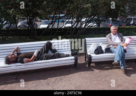 Pétersbourg, Russie. 30 juin 2024. Un sans-abri avec un plâtre sur le bras dort sur un banc. Crédit : SOPA images Limited/Alamy Live News Banque D'Images