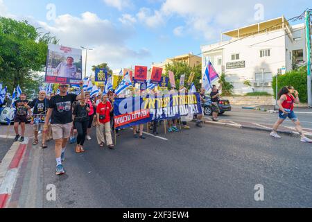 Haïfa, Israël - 29 juin 2024 : scène d'une marche de protestation, contre le gouvernement, appelant à de nouvelles élections, avec la participation de la population, divers signes et Banque D'Images