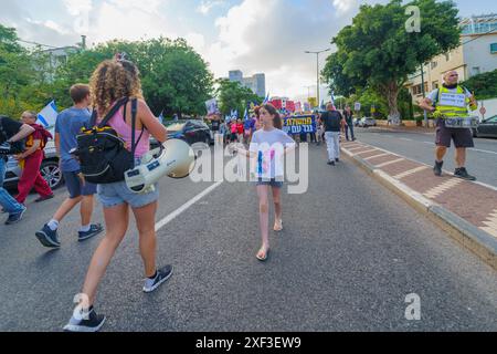 Haïfa, Israël - 29 juin 2024 : scène d'une marche de protestation, contre le gouvernement, appelant à de nouvelles élections, avec la participation de la population, divers signes et Banque D'Images