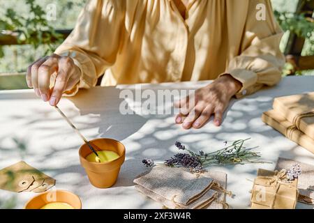 Bougie lavande d'éclairage de main femelle avec match. Aromathérapie et ambiance relaxante. Banque D'Images