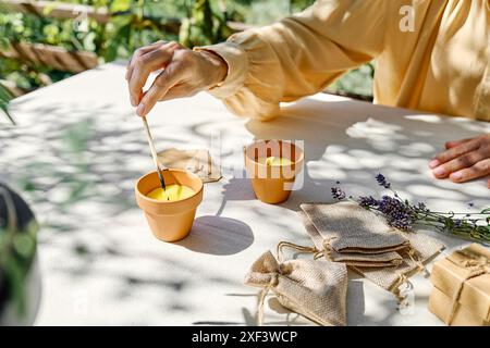 Bougie lavande d'éclairage de main femelle avec match. Aromathérapie et ambiance relaxante. Banque D'Images