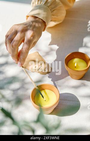 Bougie lavande d'éclairage de main femelle avec match. Aromathérapie et ambiance relaxante. Banque D'Images