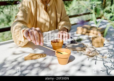 Bougie lavande d'éclairage de main femelle avec match. Aromathérapie et ambiance relaxante. Banque D'Images