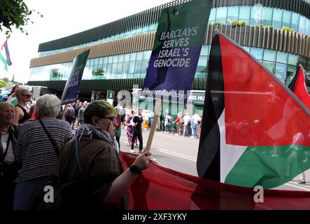 Des personnes protestant contre le parrainage des Championnats de Wimbledon par Barclays. La manifestation, organisée par la Palestine Solidarity Campaign, a vu environ 100 manifestants se tenir devant l'entrée principale de la compétition. Date de la photo : lundi 1er juillet 2024. Banque D'Images