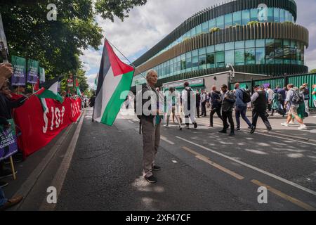 Wimbledon, Londres, Royaume-Uni 1er juillet 2024. Les manifestants pro-palestiniens se sont rassemblés devant le All England Lawn Tennis Club le premier jour des Championnats de Wimbledon avec une balle de tennis géante et des fraises « souillées de sang palestinien » pour manifester contre le parrainage par Barclay du Wimbledon qui finance, entreprises fournissant des armes et des technologies militaires utilisées par Israël à Gaza crédit : Amer Ghazzal/Alamy Live News Banque D'Images