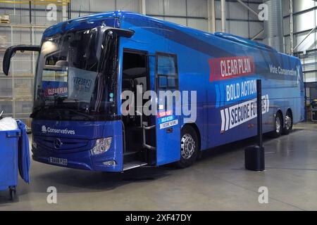 Le bus lutté contre le tory stationné alors que le premier ministre Rishi Sunak visite Well Healthcare Supplies, un centre d'emballage et de distribution de produits pharmaceutiques à Stoke-on-Trent, dans le Staffordshire, pendant la campagne électorale générale. Date de la photo : lundi 1er juillet 2024. Banque D'Images