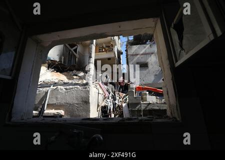 (240701) -- TULKARM, 1er juillet 2024 (Xinhua) -- des gens fouillent les décombres d'une maison touchée par un drone israélien dans le camp de réfugiés de Nour Shams, dans la ville de Tulkarm, dans le nord de la Cisjordanie, le 30 juin 2024. Un palestinien a été tué et cinq autres blessés dimanche dans une attaque de drone israélien ciblant une maison dans le camp de réfugiés de Nour Shams dans la ville de Tulkarem dans le nord de la Cisjordanie, ont indiqué des sources palestiniennes. (Photo de Nidal Eshtayeh/Xinhua) Banque D'Images