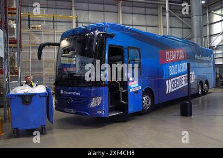 Le bus lutté contre le tory stationné alors que le premier ministre Rishi Sunak visite Well Healthcare Supplies, un centre d'emballage et de distribution de produits pharmaceutiques à Stoke-on-Trent, dans le Staffordshire, pendant la campagne électorale générale. Date de la photo : lundi 1er juillet 2024. Banque D'Images