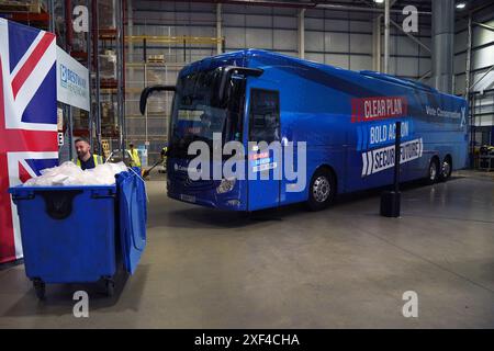 Le bus lutté contre le tory stationné alors que le premier ministre Rishi Sunak visite Well Healthcare Supplies, un centre d'emballage et de distribution de produits pharmaceutiques à Stoke-on-Trent, dans le Staffordshire, pendant la campagne électorale générale. Date de la photo : lundi 1er juillet 2024. Banque D'Images