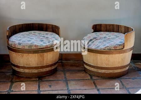 2 vieux tabourets ronds bas en bois avec des coussins sales à l'intérieur d'un entrepôt Banque D'Images