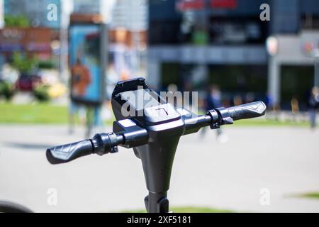 Gros plan du guidon bleu électrique sur un scooter électrique, en métal. Le scooter est à l'extérieur sur l'herbe, guidon de vélo mots-clés, véh moteur Banque D'Images