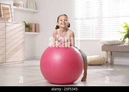 Petite fille mignonne avec balle en forme à la maison Banque D'Images