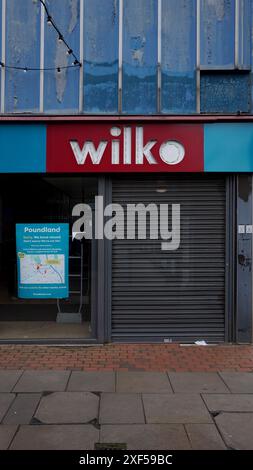 Wilkinsons magasin vide sur High Street, fenêtres vides, fascia toujours visible, pourriture urbaine, volets. Banque D'Images