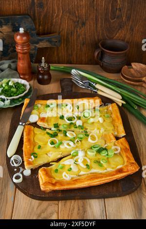 Tarte à pâte feuilletée maison ou galette avec pommes de terre, fromage à la crème et romarin sur fond de table en bois ancien. Plat traditionnel britannique plat maison o Banque D'Images