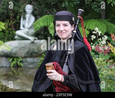 Londres, Royaume-Uni. 01 juillet 2024. Une joueuse de cornemuse avec le Royal cornemuse Band of Ourense, en tenue traditionnelle galicienne, pose dans la voie de Saint James Show Garden. En avant-première de la presse traditionnelle au RHS Hampton court Palace Garden Festival (anciennement le Hampton court Flower Show). Le festival sera ouvert au public le mardi 2 juillet pour célébrer le meilleur du jardinage estival. Crédit : Imageplotter/Alamy Live News Banque D'Images