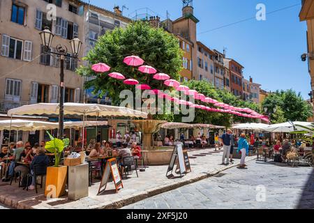 Parapluies roses flottantes au-dessus des boutiques et restaurants de la place aux Aires dans la vieille ville de Grasse sur la Côte d'Azur, Côte d'Azur, Provence, France Banque D'Images