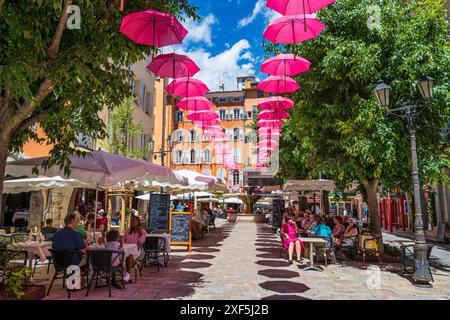 Parapluies roses flottantes au-dessus des boutiques et restaurants de la place aux Aires dans la vieille ville de Grasse sur la Côte d'Azur, Côte d'Azur, Provence, France Banque D'Images