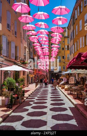 Parapluies roses flottantes au-dessus des boutiques et restaurants de la place aux Aires dans la vieille ville de Grasse sur la Côte d'Azur, Côte d'Azur, Provence, France Banque D'Images