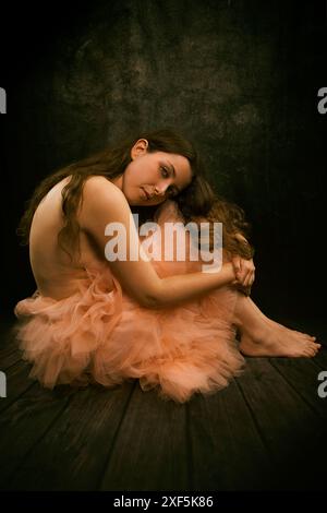 Femme avec jupe en tulle rose, assise sur le sol dans une attitude romantique II, espagne Banque D'Images