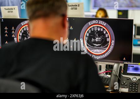 Uedem, Allemagne. 01 juillet 2024. Un soldat de la Bundeswehr est assis devant des moniteurs dans la salle de commandement de la surveillance de l'espace aérien à Uedem. La Bundeswehr présente la protection de l'espace aérien lors des Championnats d'Europe de football. La Bundeswehr a mis en place un centre d'opérations aériennes pour fournir une assistance administrative aux forces de police des états fédéraux et au contrôle aérien allemand. Crédit : Christoph Reichwein/dpa/Alamy Live News Banque D'Images