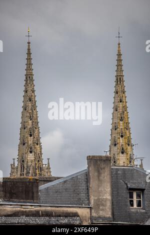 Flèches architecturales gothiques de la cathédrale Saint-Corentin planant vers le ciel à Quimper, Bretagne, France par une journée nuageuse. Banque D'Images