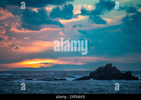 Superbe coucher de soleil sur le rivage rocheux de la péninsule de Quiberon en Bretagne, France. Couleurs vibrantes dans le ciel reflétant les vagues de l'océan. Banque D'Images
