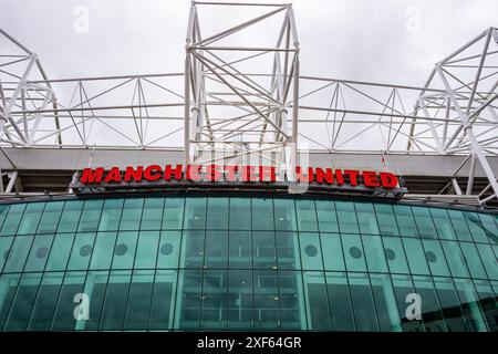 Manchester Trafford UK 29 juin 2024. Entrée emblématique du stade de football avec un grand panneau rouge sous un ciel couvert. Banque D'Images