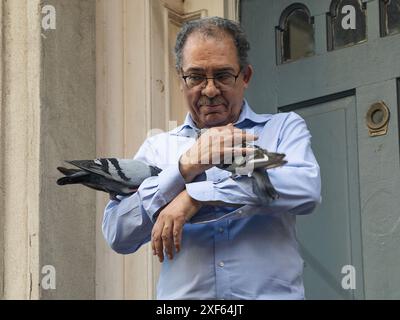 Un homme caresse des pigeons à New York, New York, USA 20 septembre 2023 Banque D'Images