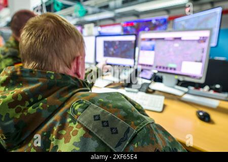 Uedem, Allemagne. 01 juillet 2024. Un soldat de la Bundeswehr est assis devant des moniteurs dans la salle de commandement de la surveillance de l'espace aérien à Uedem. La Bundeswehr présente la protection de l'espace aérien lors des Championnats d'Europe de football. La Bundeswehr a mis en place un centre d'opérations aériennes pour fournir une assistance administrative aux forces de police des états fédéraux et au contrôle aérien allemand. Crédit : Christoph Reichwein/dpa/Alamy Live News Banque D'Images
