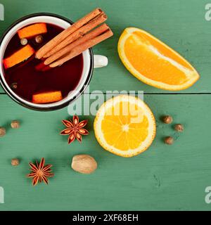 Vin chaud dans des tasses rustiques blanches avec épices et agrumes. Banque D'Images