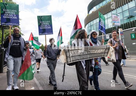 Londres, Royaume-Uni. 1er juillet 2024. Des activistes pro-palestiniens de la campagne de solidarité palestinienne (PSC), War on Want et Campaign Against Arms Trade (CAAT) manifestent devant Wimbledon contre les investissements et prêts de Barclays dans les entreprises d'armement qui vendent des armes et des technologies militaires à Israël. 1 milliard à 9 sociétés fournissant des armes et des technologies militaires à Israël. Crédit : Mark Kerrison/Alamy Live News Banque D'Images