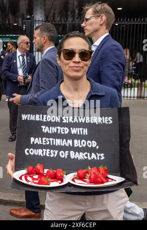 Londres, Royaume-Uni. 1er juillet 2024. Un activiste pro-palestinien tient un accessoire contenant des fraises lors d'une manifestation devant Wimbledon organisée par Palestine Solidarity Campaign (PSC), War on Want et Campaign Against Arms Trade (CAAT) pour mettre en lumière les investissements et prêts de Barclays dans des sociétés d'armement qui vendent des armes et des technologies militaires à Israël. Crédit : Mark Kerrison/Alamy Live News Banque D'Images