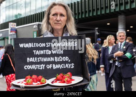 Londres, Royaume-Uni. 1er juillet 2024. Un activiste pro-palestinien tient un accessoire contenant des fraises lors d'une manifestation devant Wimbledon organisée par Palestine Solidarity Campaign (PSC), War on Want et Campaign Against Arms Trade (CAAT) pour mettre en lumière les investissements et prêts de Barclays dans des sociétés d'armement qui vendent des armes et des technologies militaires à Israël. Crédit : Mark Kerrison/Alamy Live News Banque D'Images