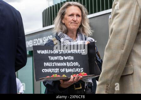 Londres, Royaume-Uni. 1er juillet 2024. Un activiste pro-palestinien tient un accessoire contenant des fraises lors d'une manifestation devant Wimbledon organisée par Palestine Solidarity Campaign (PSC), War on Want et Campaign Against Arms Trade (CAAT) pour mettre en lumière les investissements et prêts de Barclays dans des sociétés d'armement qui vendent des armes et des technologies militaires à Israël. Crédit : Mark Kerrison/Alamy Live News Banque D'Images