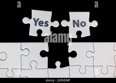 Un puzzle avec deux pièces qui disent oui et non. La scène est sérieuse et incite à réfléchir Banque D'Images