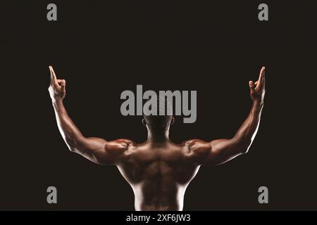 Homme musclé levant les bras dans la posture de la victoire Banque D'Images