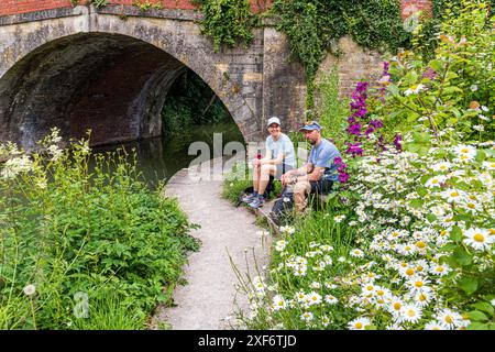 Un jeune couple de Suède marchant le Cotswold Way profitant d'un repos à côté du pont sur la navigation Stroudwater à Ryeford près de Stonehouse UK Banque D'Images