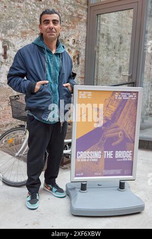 Hambourg, Allemagne. 01 juillet 2024. Fatih Akin, réalisatrice, se tient à côté de l'affiche du film dans le hall à l'occasion de la sortie du film 'traverser le pont - le son d'Istanbul' à Zeise Kino. Crédit : Georg Wendt/dpa/Alamy Live News Banque D'Images