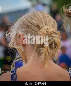 Un gros plan d'une femme blonde avec une élégante coiffure updo ornée de perles lors d'un événement de bal en plein air à Ludvika, en Suède. Prise de vue verticale. Banque D'Images