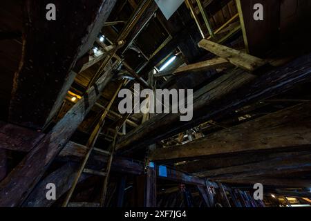 La ferme de toit de l'ancien hôtel de ville de Brême a une caractéristique structurelle particulière. L'une des deux structures indépendantes supporte le toit en cuivre et l'autre le plafond de la salle supérieure. De cette façon, les forces de traction qui chargeraient normalement la ferme de toit sont absorbées par le poids du plafond et réparties sur les parois extérieures. Cette solution d'ingénierie assure une stabilité et une longévité exceptionnelles de la ferme de toit historique. Brême, Allemagne Banque D'Images