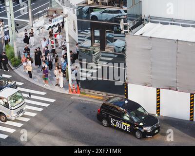 TOKYO, JAPON - 16 juin 2024 : vue aérienne d'un coin de rue à Ginza avec une boîte de police, le Sanai Dream Center sous-démolition et un taxi. Banque D'Images