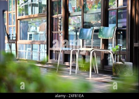 Taïwan - 29 janvier 2024 : gros plan de deux chaises d'école industrielles françaises bleues sur le patio ensoleillé d'une maison japonaise en bois. Aimé par les étudiants pour Banque D'Images