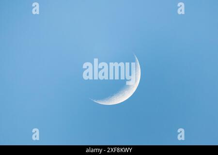 Crescent est dans le ciel bleu sur une vue de jour, gros plan avec des détails sur la surface de la lune, photo astronomique naturelle Banque D'Images