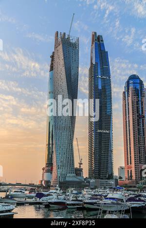 Dubaï, UEA - 23 février. 2023 : bâtiments futuristes de grande hauteur de Dubaï en construction au coucher du soleil dans la zone animée de la marina. Banque D'Images