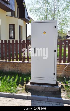 Boîte électrique, mesure de compteur électrique près de la clôture de la maison. Gros plan sur le boîtier de commande métallique interne du tableau de commutation électrique dans la rue. Banque D'Images