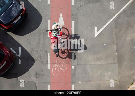 Cycliste projette une longue ombre, voyageant sur une piste cyclable marquée en rouge. Miltenberg, basse-Franconie, Bavière, Allemagne Banque D'Images