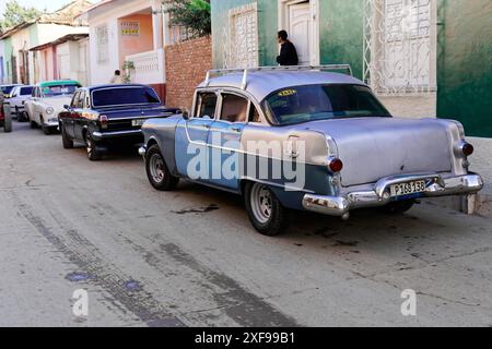 Trinité, Cuba, Grande Antilles, Caraïbes, Amérique centrale, Amérique, Une rangée de voitures anciennes garées dans une rue historique avec des maisons colorées dans le Banque D'Images